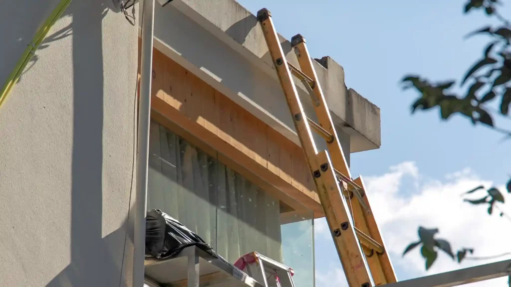 An extension ladder resting on a building