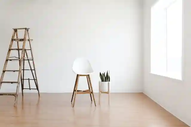 a ladder in a sunny room next to a white chair